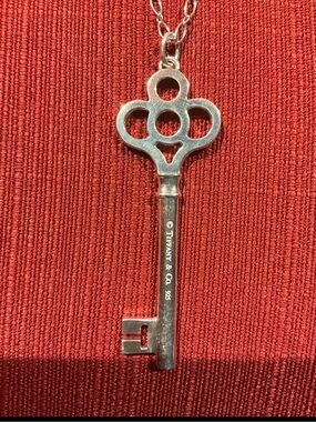 Tiffany & Co. Silver Key Pendant on Chain - Red Background